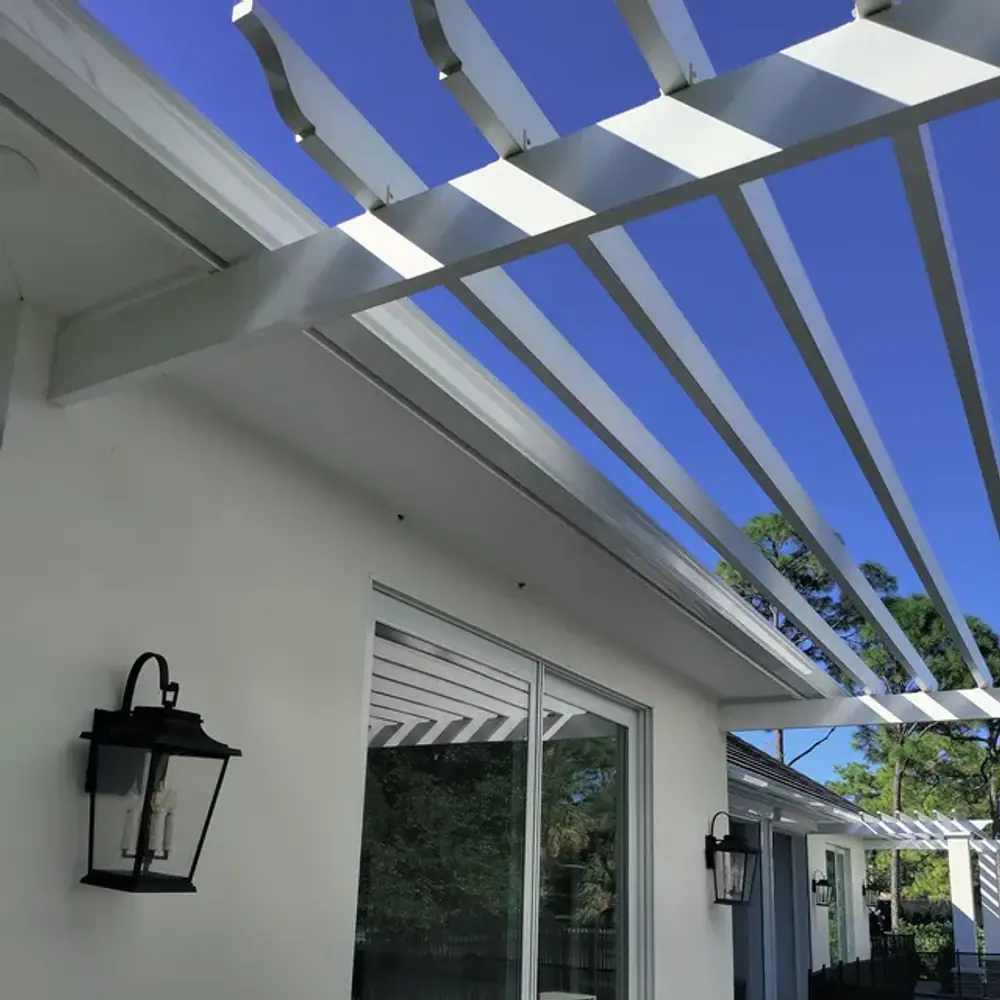 White seamless gutters on a covered patio with pergola