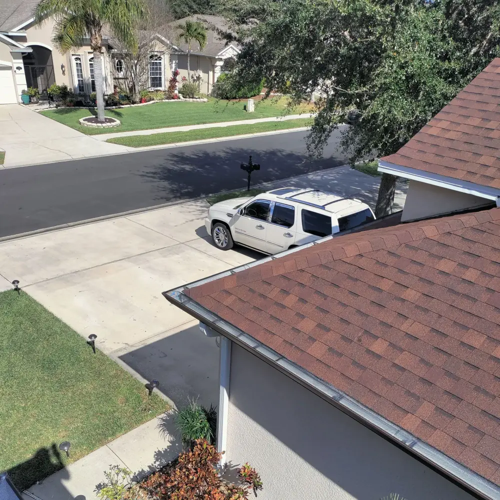Seamless gutter with leaf guard along a shingle roof