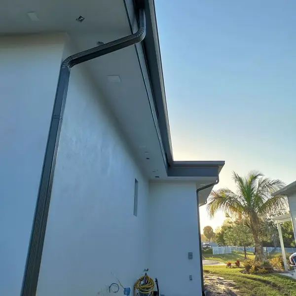 Dark bronze downspout on a white stucco home